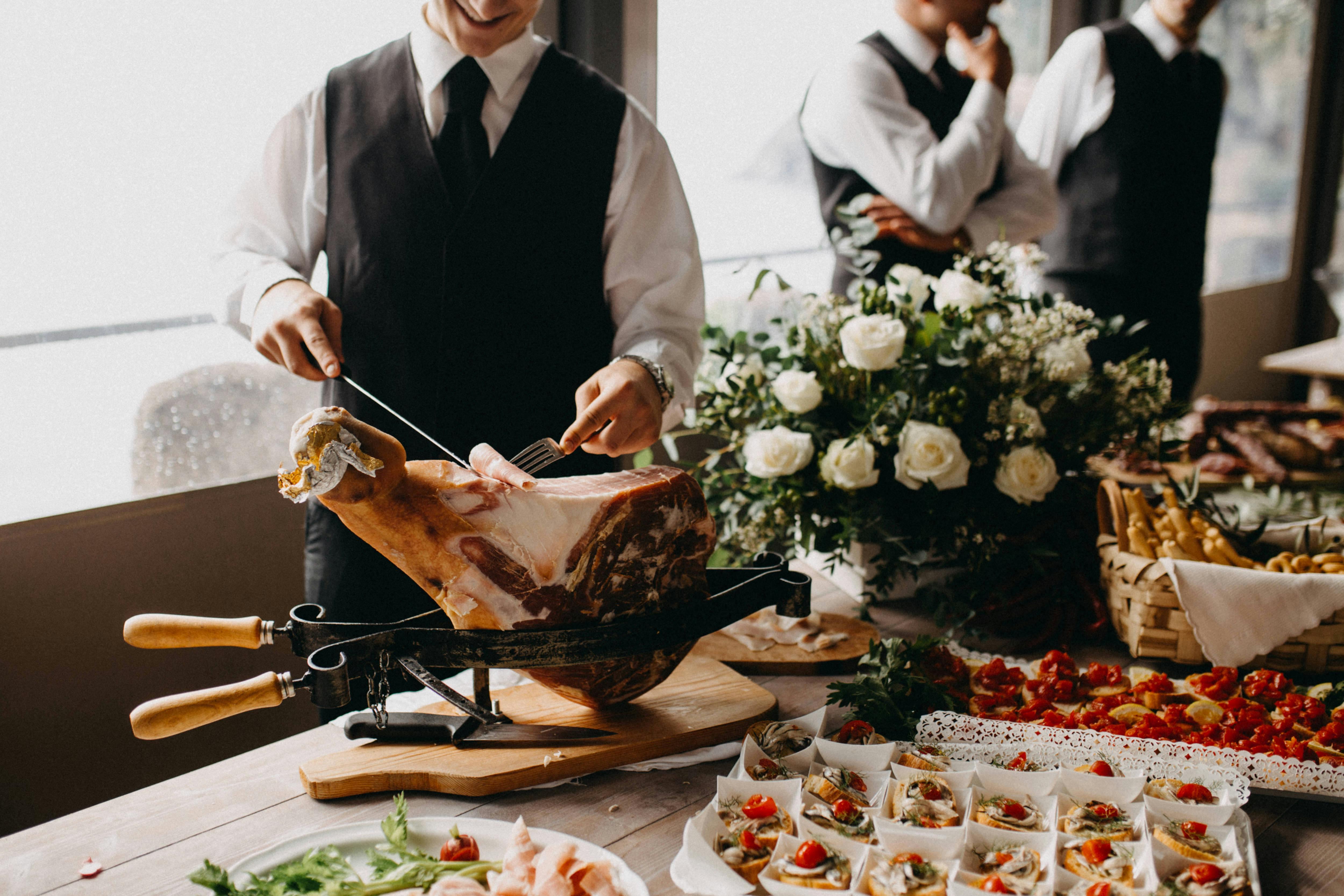 A chef attendant carves a piece of meat.