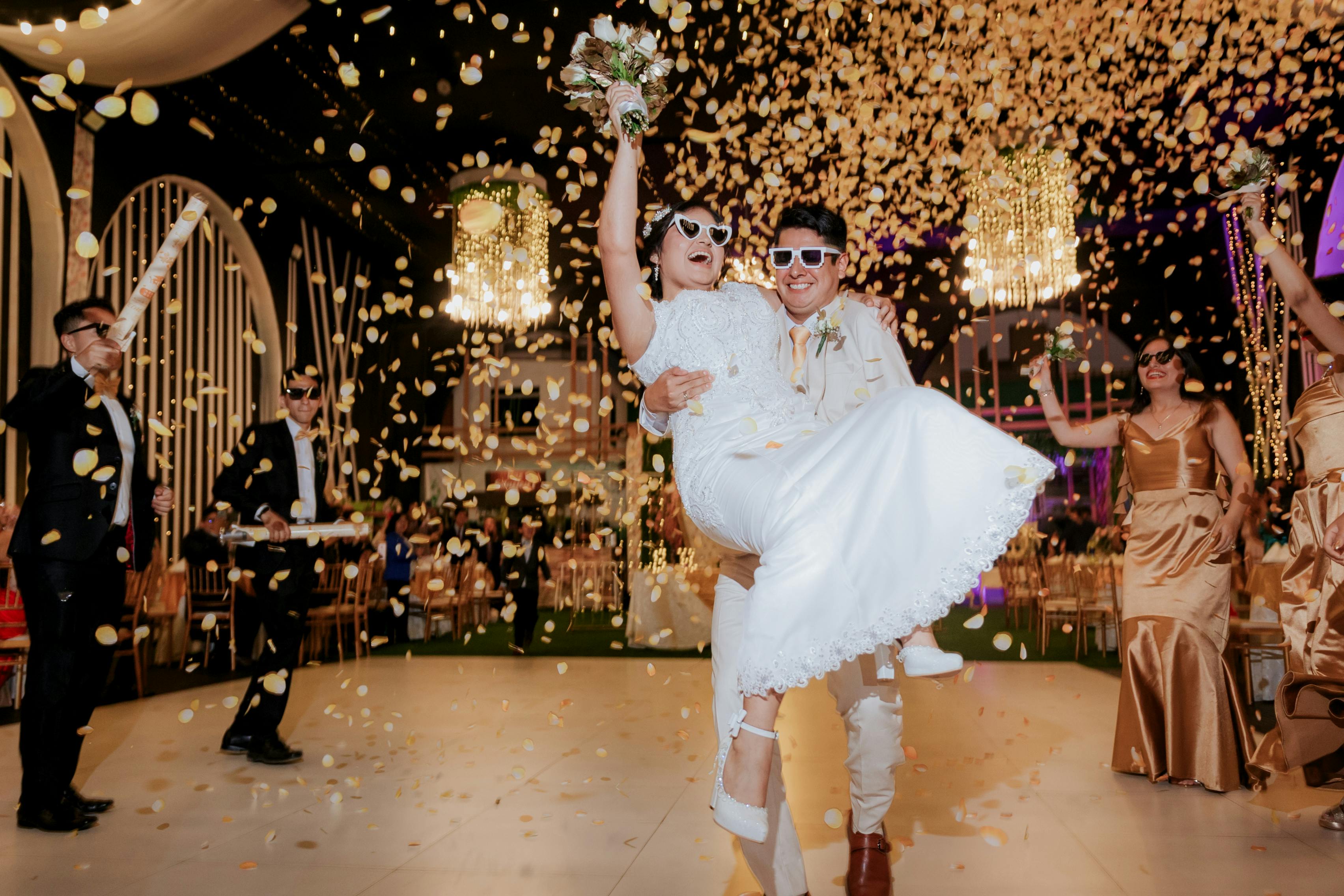 A bride and groom celebrate as confetti is thrown around them.