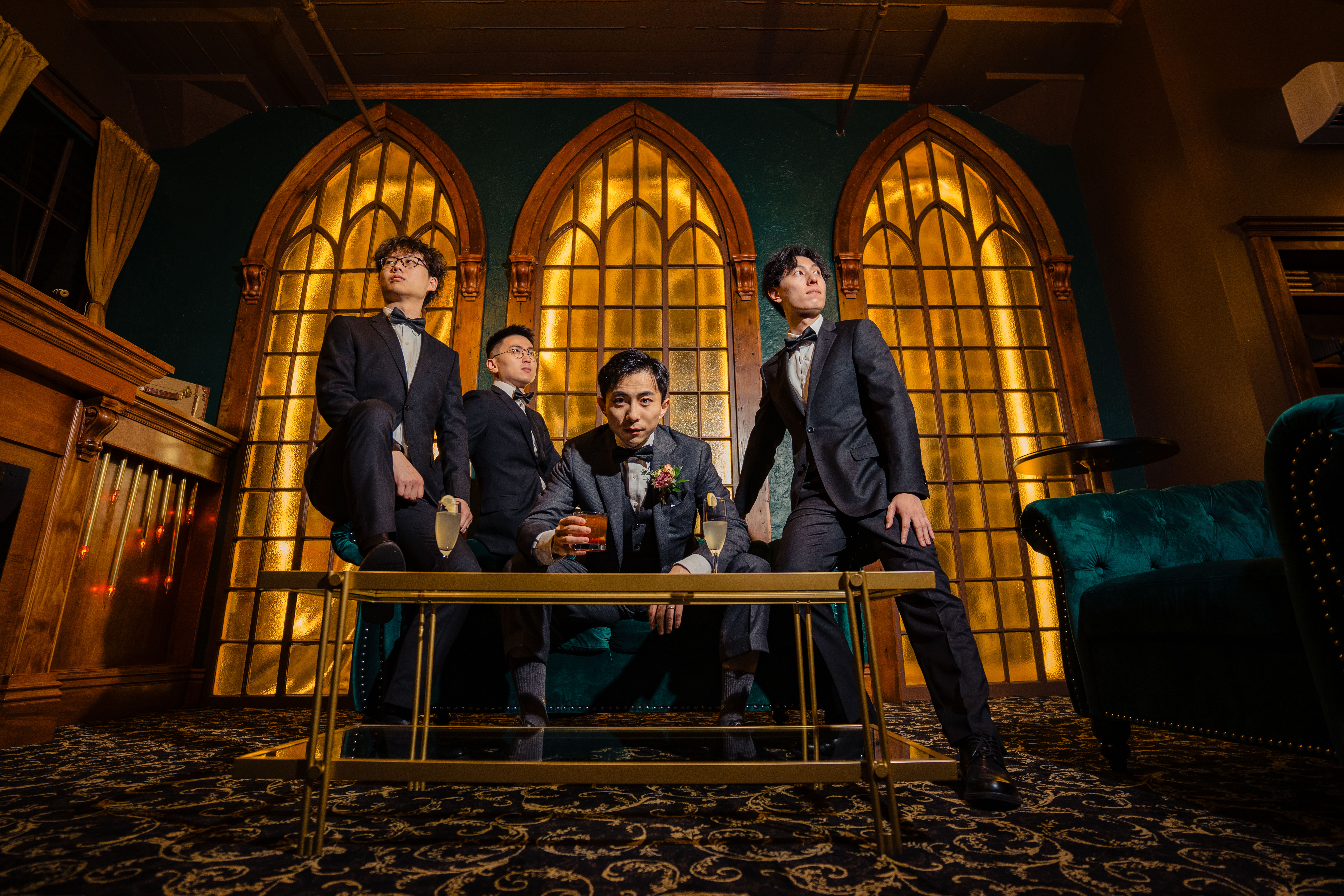 Groom and groomsmen posing for a photo in front of the 3 Gothic-style windows in the Rhapsody Suite