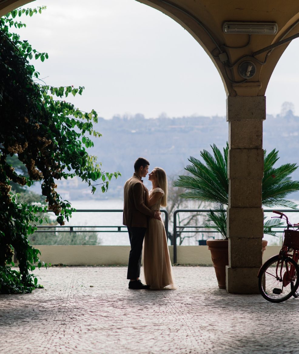 husband in uniform kissing wife in white wedding dress outside