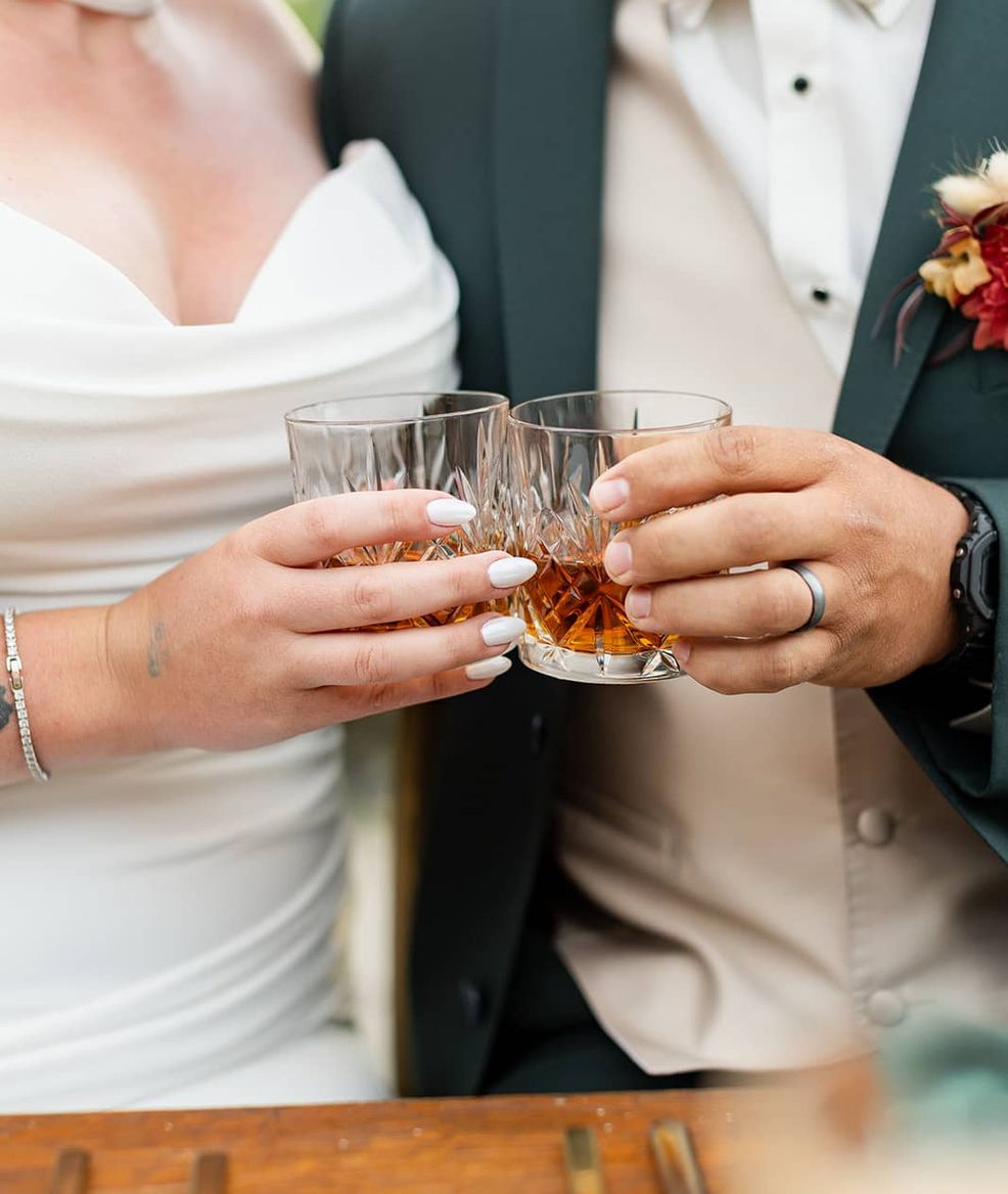 husband and wife clanking together a whisky glass