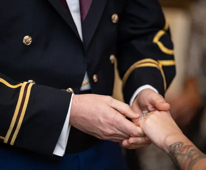 military wedding with brides hand in husbands hand