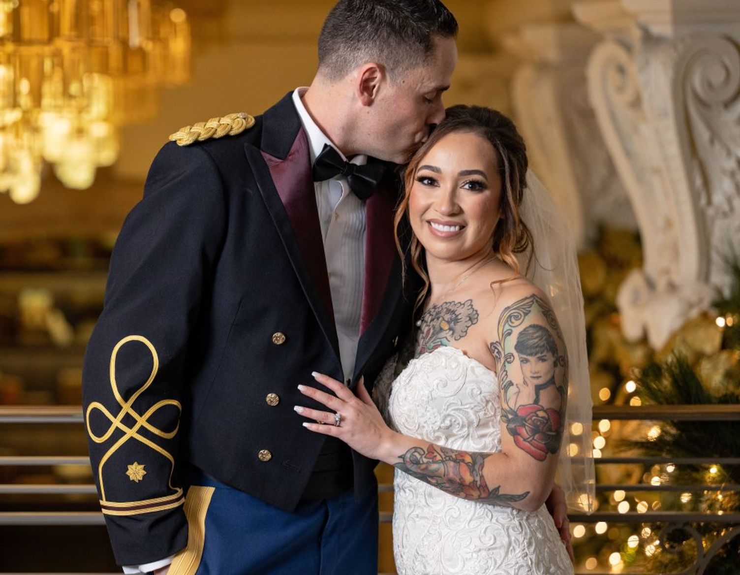 man in uniform with bride in white dress looking into each others eyes