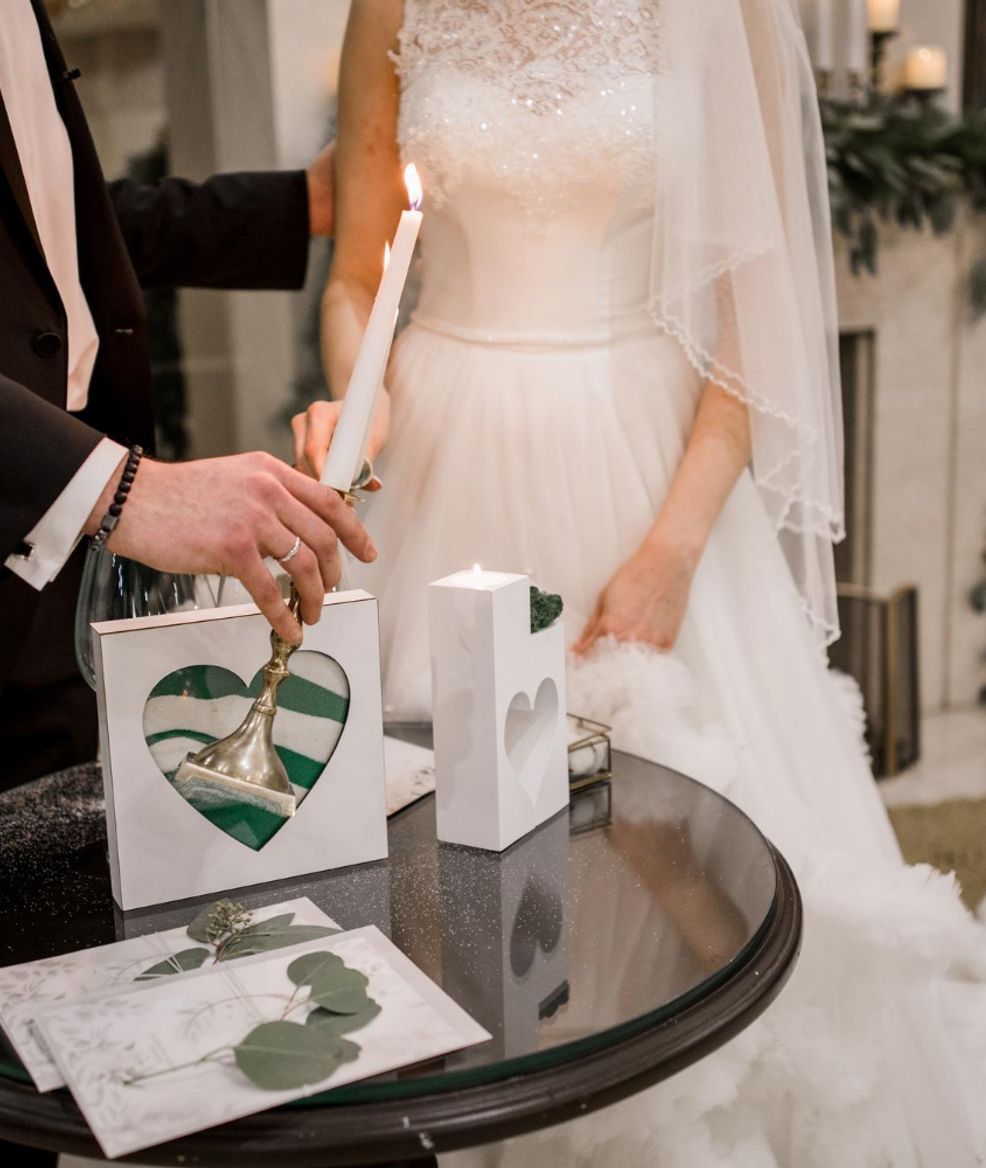 husband and bride lighting a candle