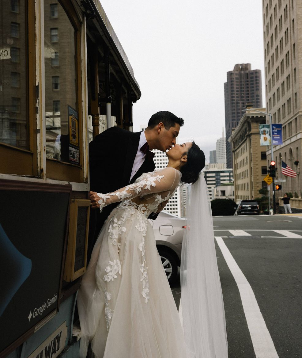 a brife and a groom kissing on a tram